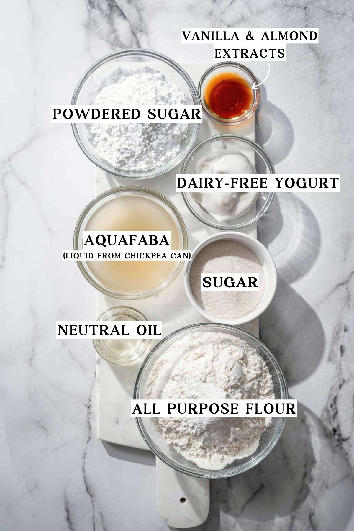 Ingredients for vegan ladyfinger cookies including aquafaba, dairy-free yogurt, sugar, flour, oil, and vanilla and almond extracts.