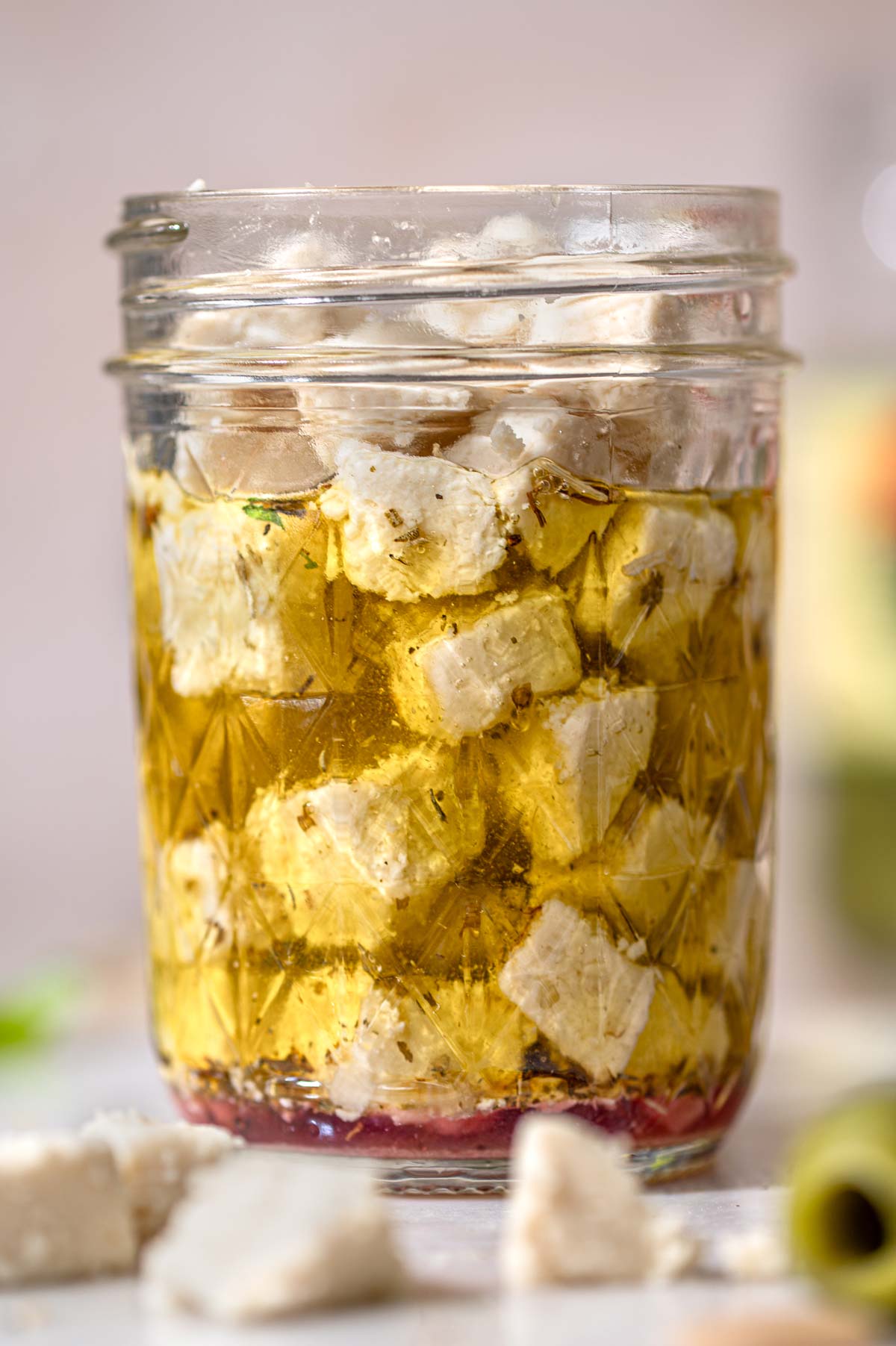 a glass jar filled with marinated dairy free feta.