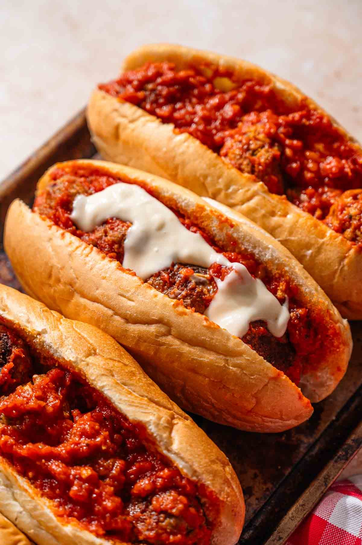 the assembled vegan meatball sub with cheese sauce on top before being broiled. 