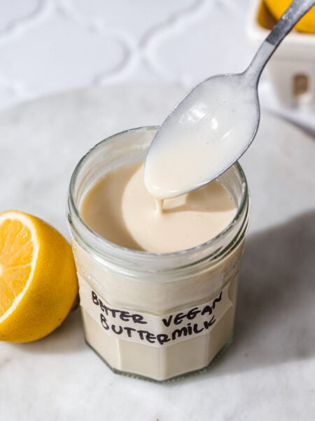 a jar of vegan buttermilk with a spoon dipping in it.