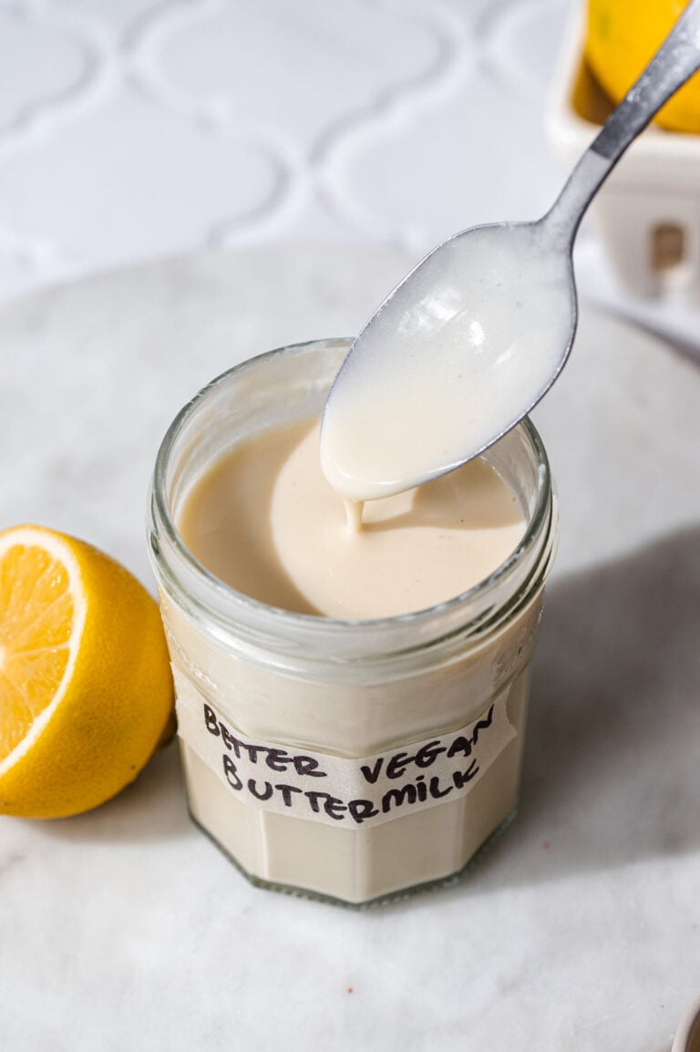 a jar of vegan buttermilk with a spoon dipping in it.