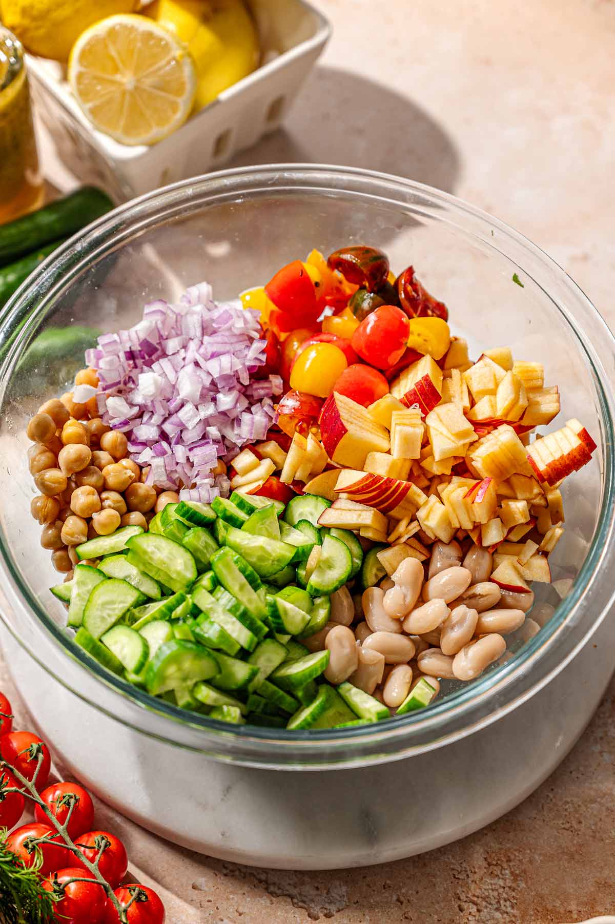 ingredients for the herby bean salad in a glass mixing bowl.