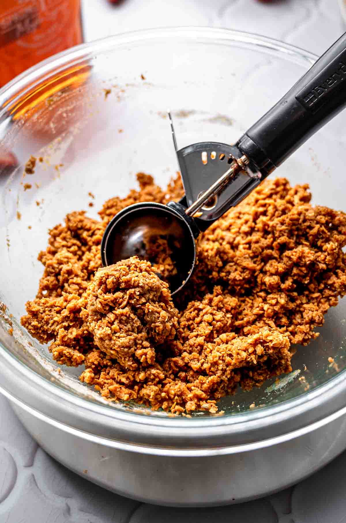 the vegan sausage patty dough with a scoop in a large glass bowl.