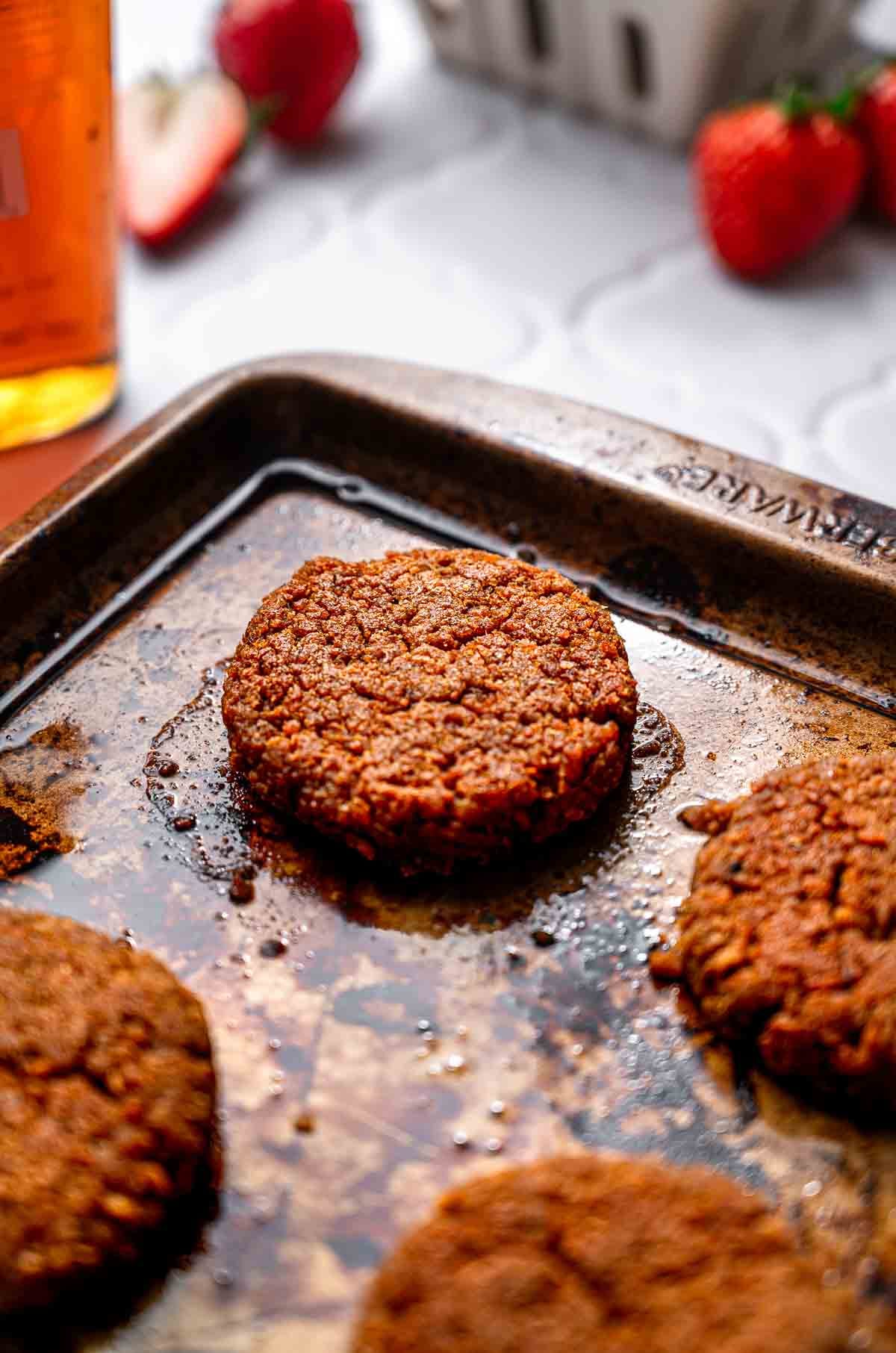 the shaped vegan sausage on an oiled baking sheet after baking.