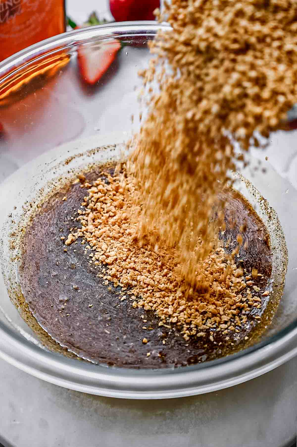 TVP being poured into a glass bowl with seasoned hot water.