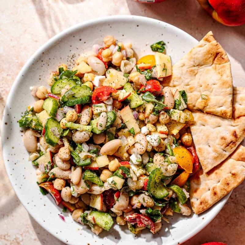 a speckled plate with a Mediterranean inspired white bean salad tossed in lemon dessing.