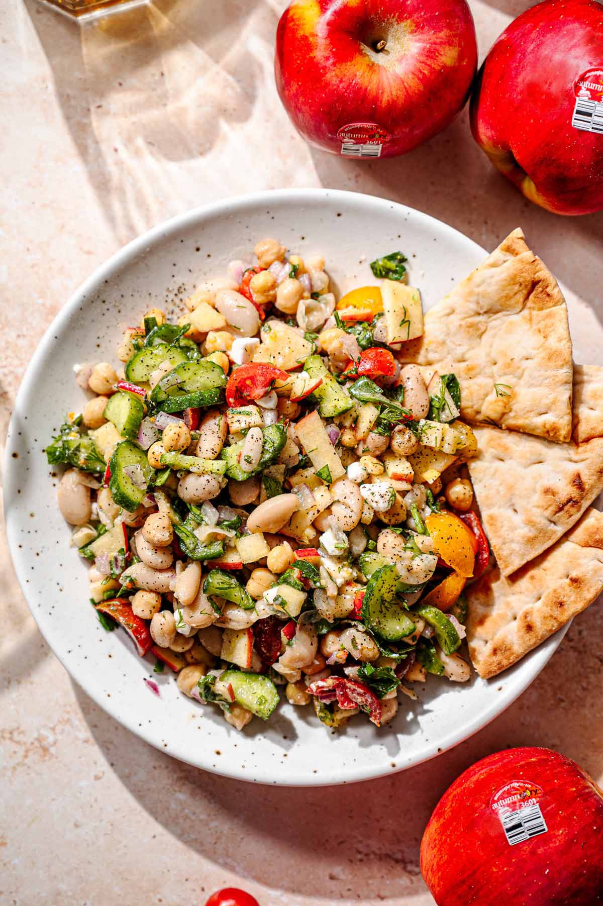 a speckled plate with a Mediterranean inspired white bean salad tossed in lemon dessing.