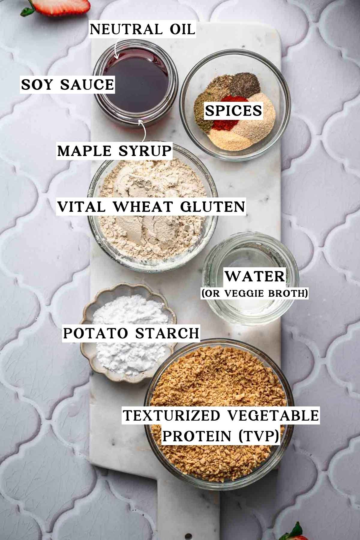 ingredients for vegan sausage like TVP, vital wheat gluten and spices on a marble tray.