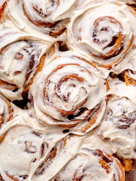 a top view of the baked vegan cinnamon rolls topped with a cream cheese frosting.