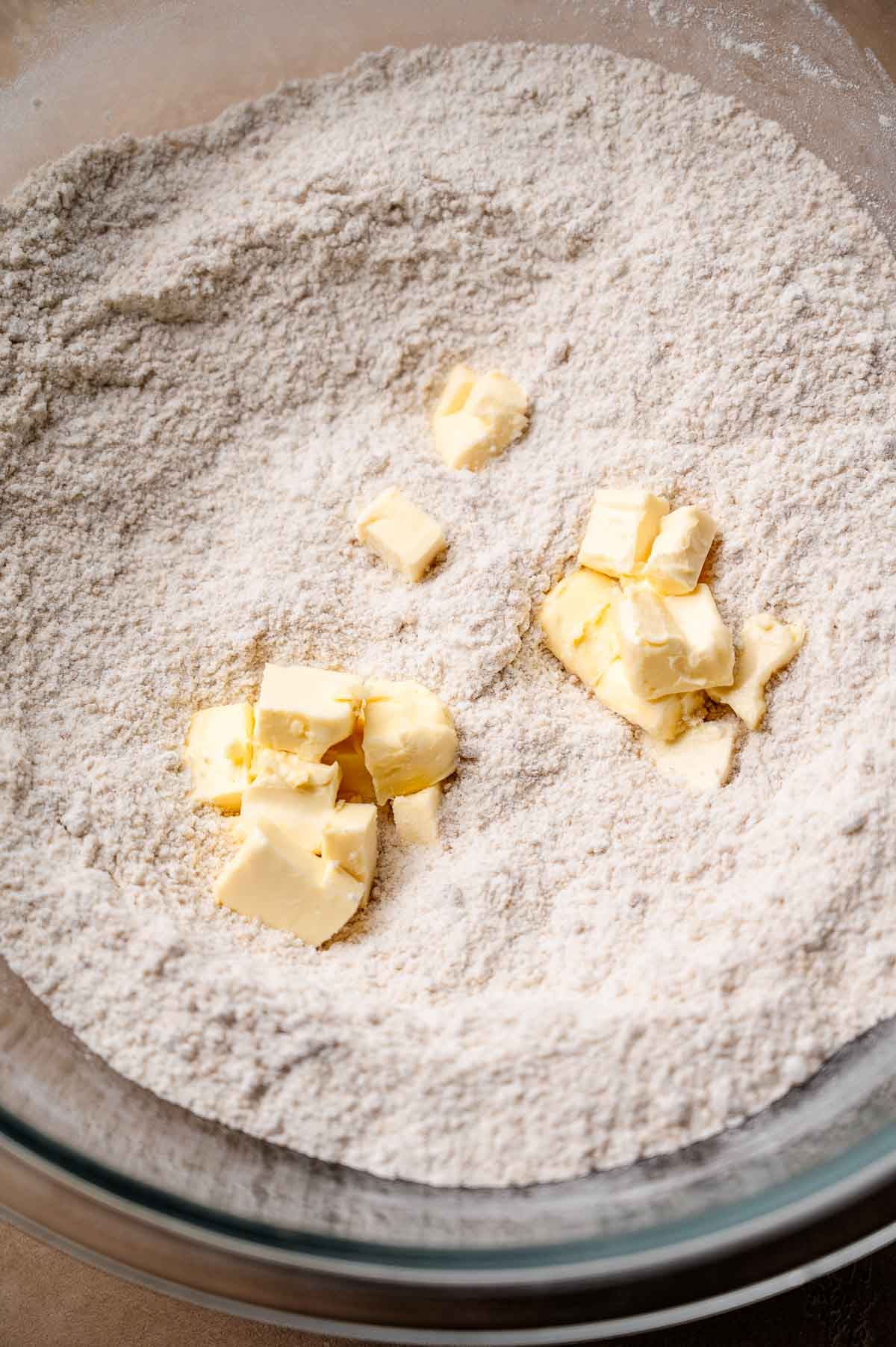 chunks of vegan butter in a the mixed dry ingredients.