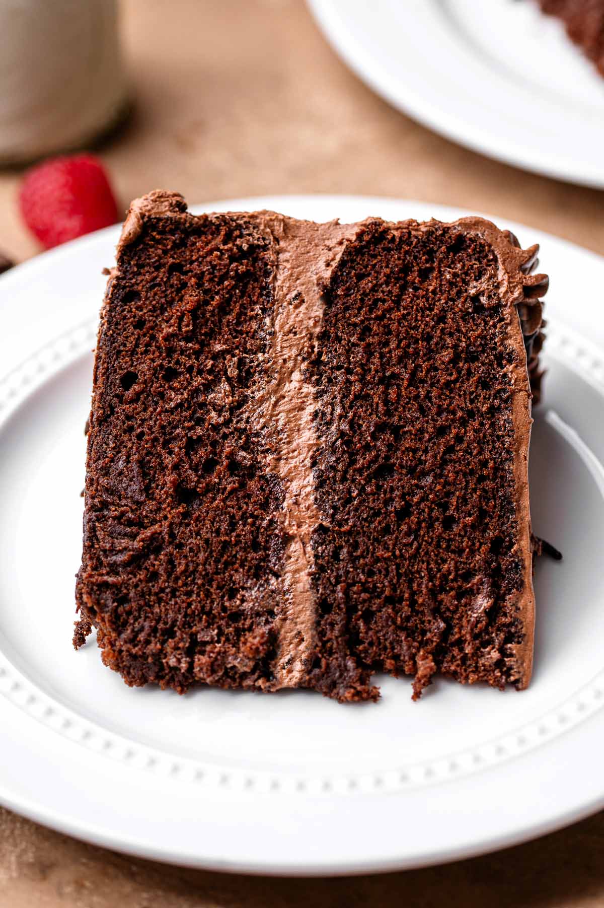 a slice of vegan chocolate cake on a white plate.