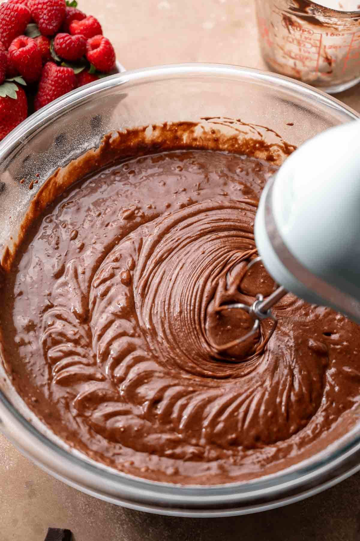 mixing the chocolate cake batter with hand mixers.