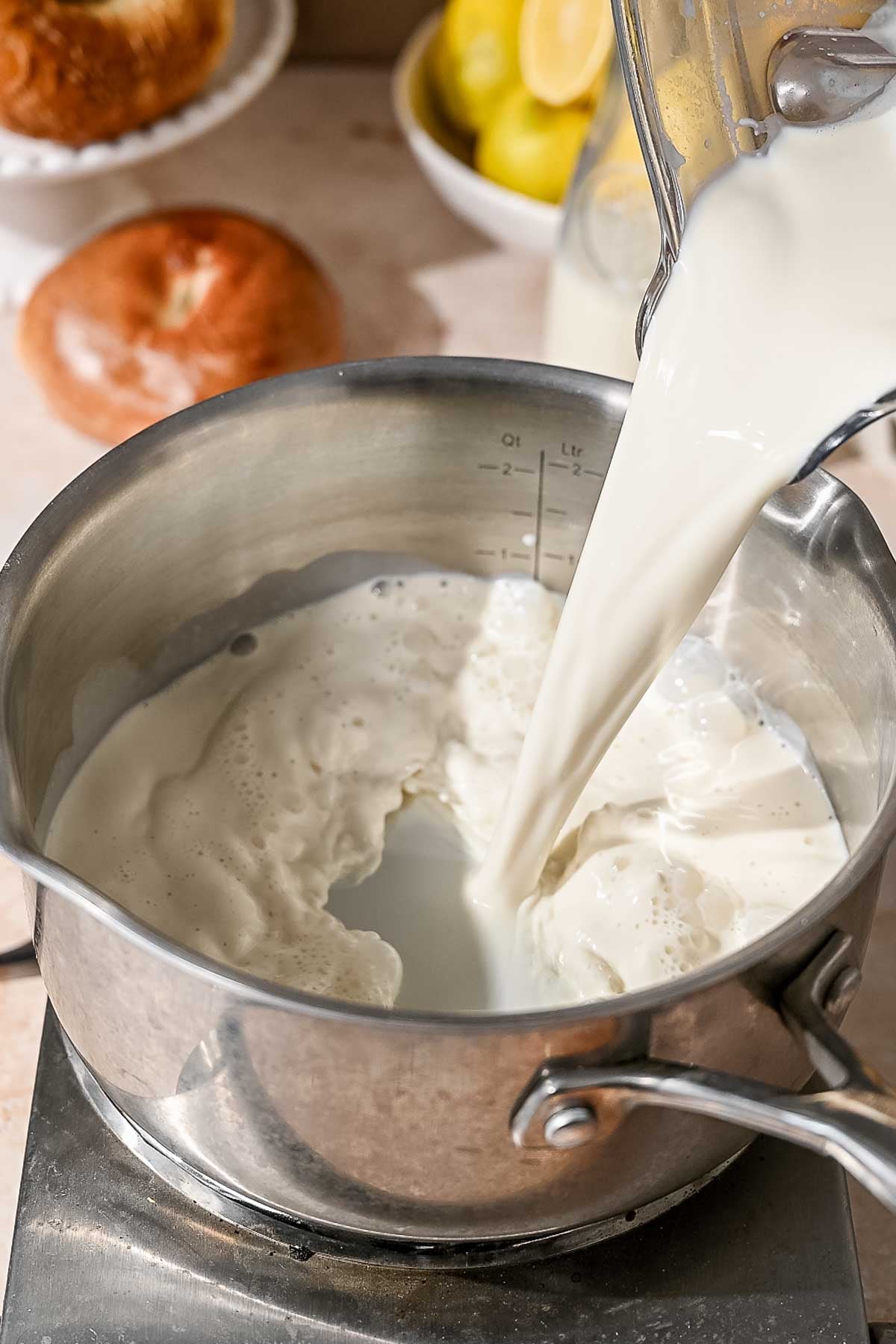blended soy milk being poured into a stainless steel pot.