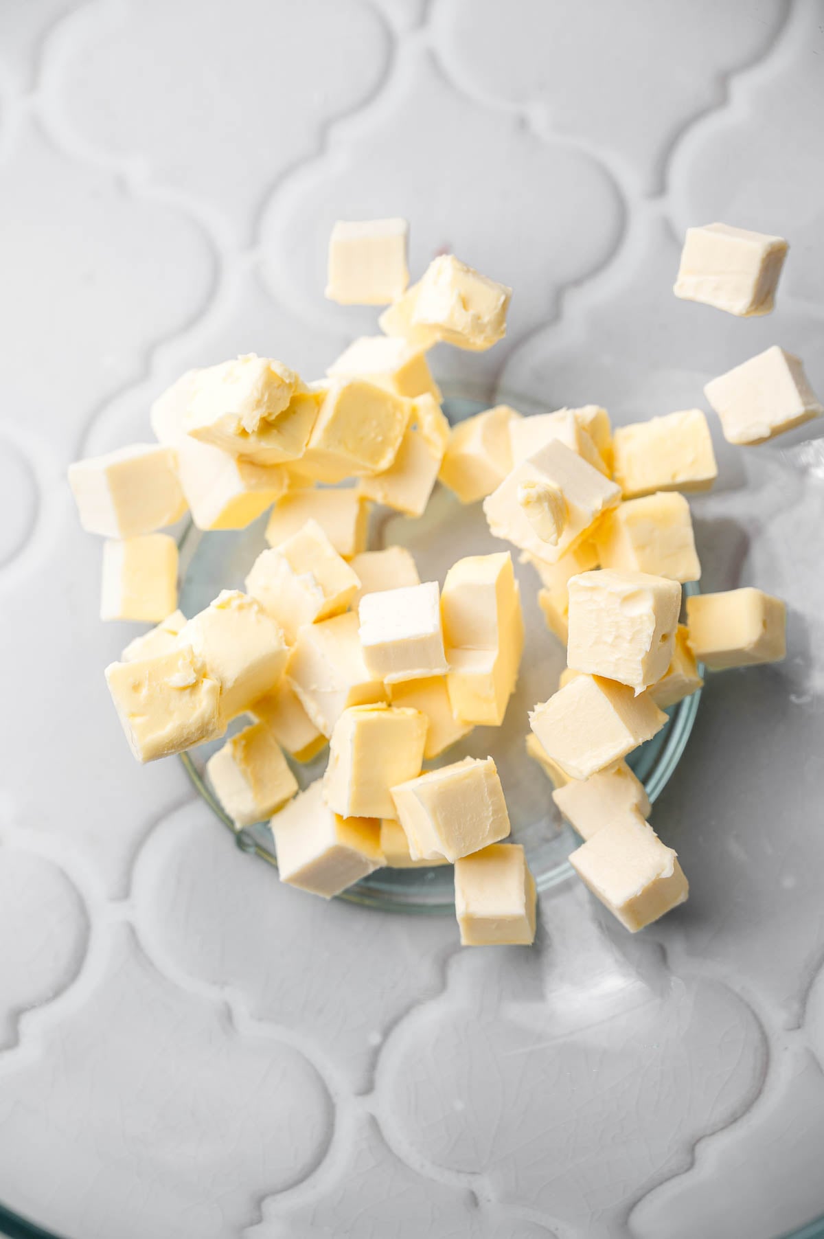 a close up image of cubed vegan butter in a large glass bowl.