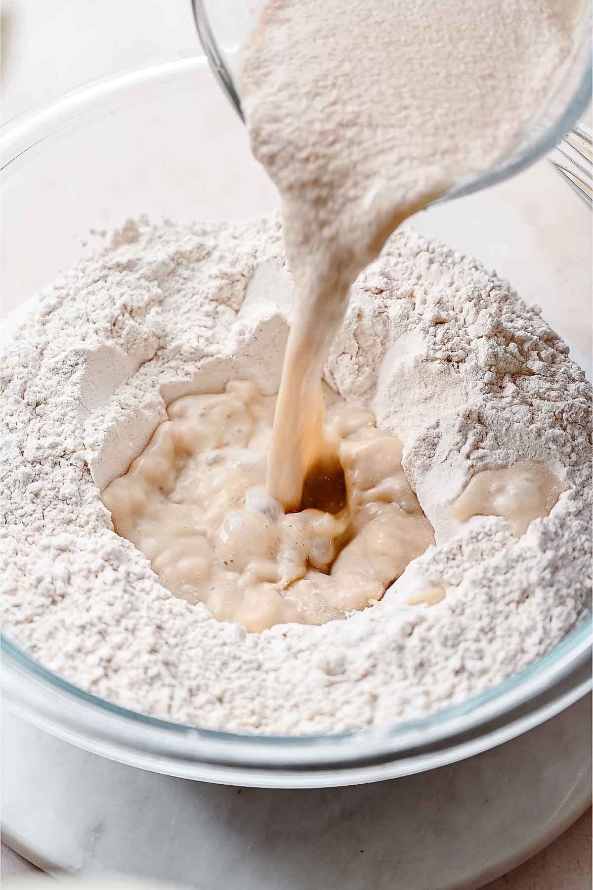 a large bowl with milk and yeast being poured in the center.
