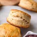 a flaky vegan buttermilk biscuit resting on another biscuit.