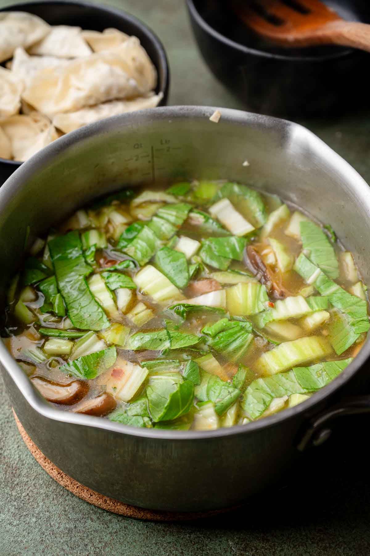 bok choy added to the veggie dumpling soup broth.