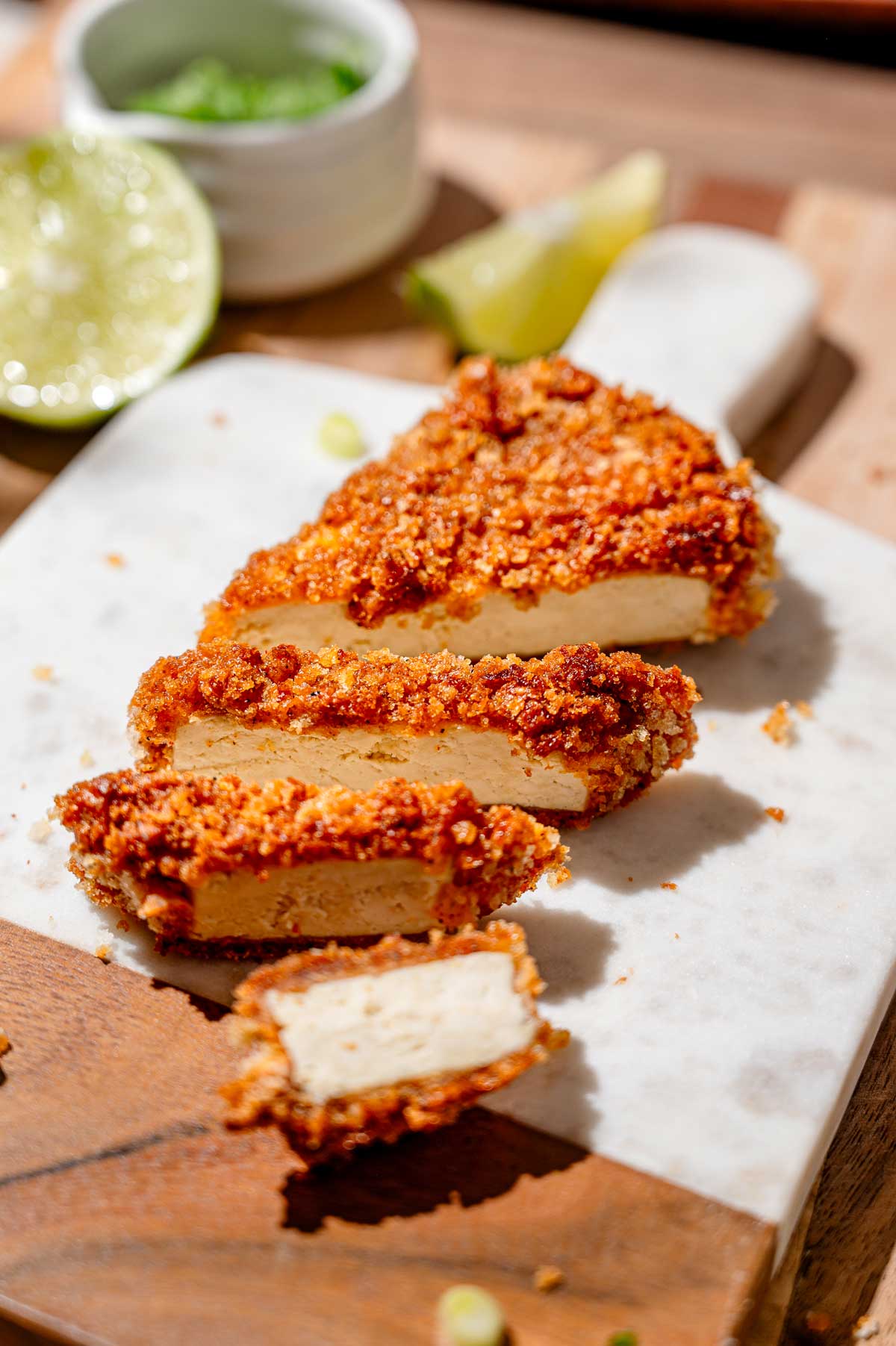 crispy panko breaded tofu sliced on a marble cutting board.