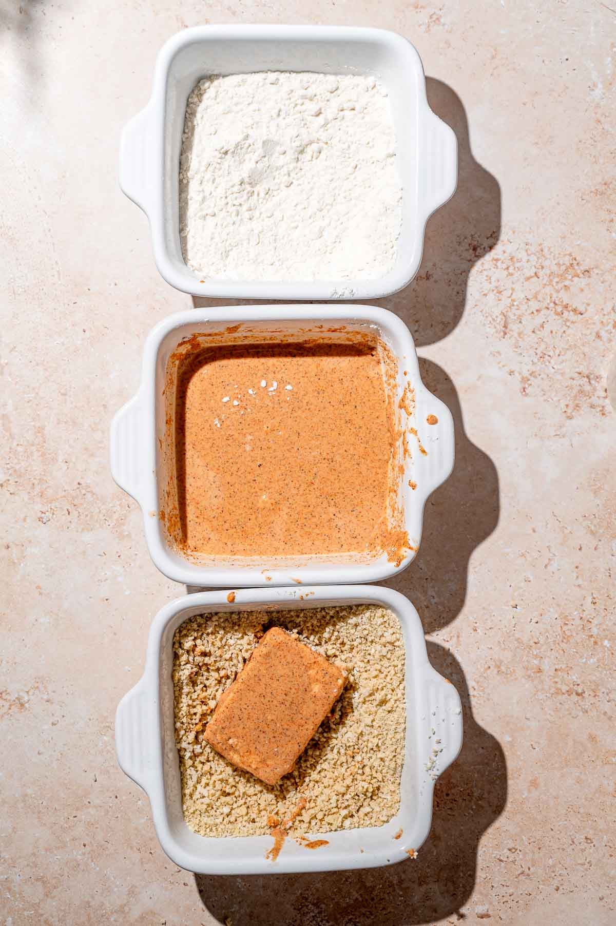 three shallow dishes with flour, cornstarch batter and panko breadcrumbs.