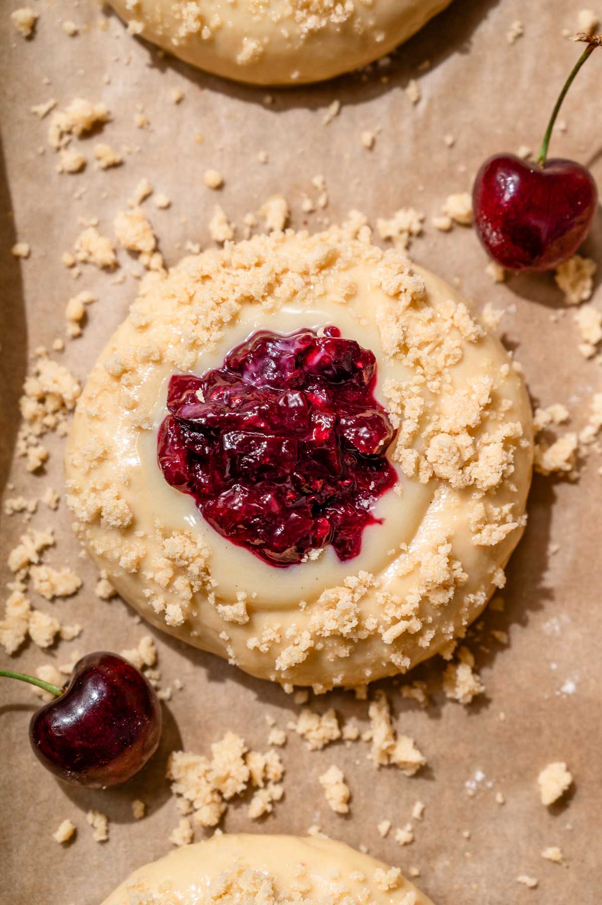 an unbaked brioche bun filled with vegan custard and cherries.