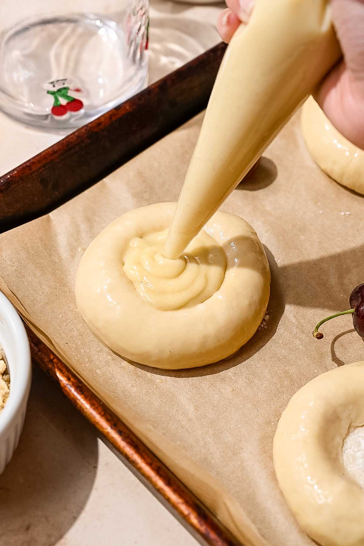 vegan custard being piped into brioche buns.