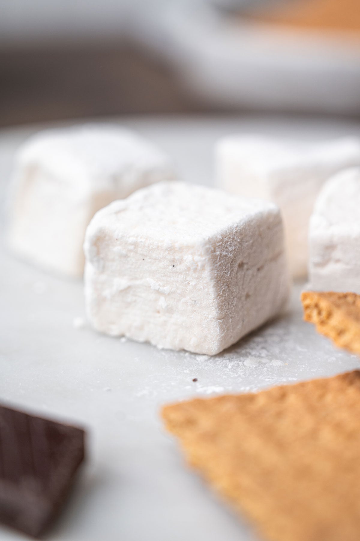 Homemade vegan marshmallow on a plate with graham crackers and chocolate.