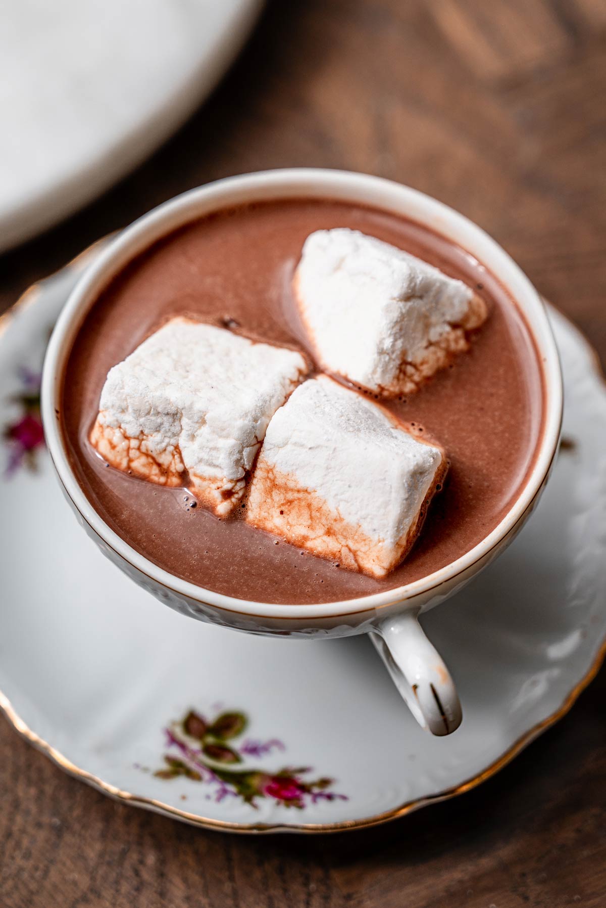 Vegan marshmallows melting into a cup of hot chocolate.