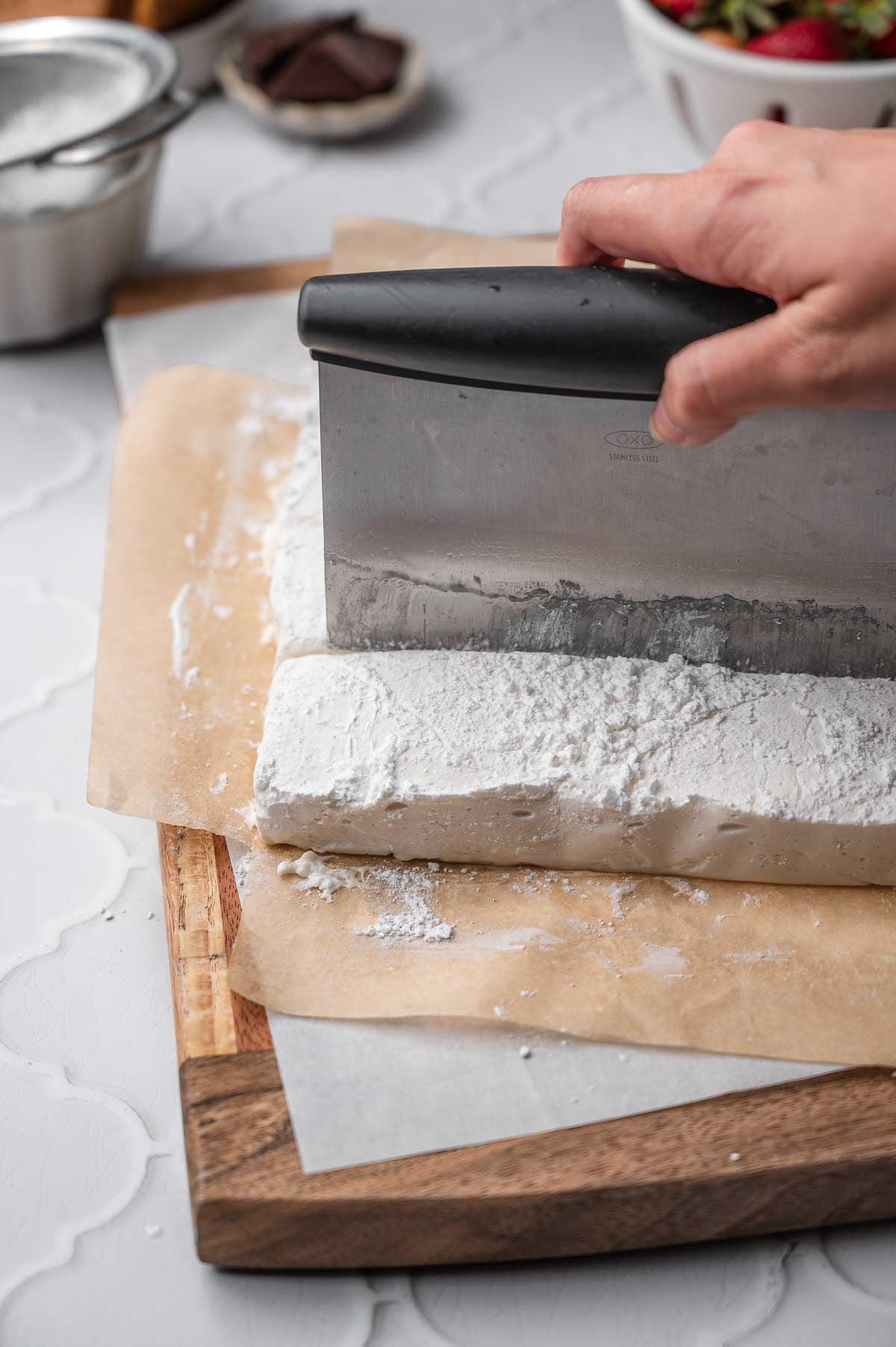 cutting the vegan marshmallow with an oiled bench cutter.