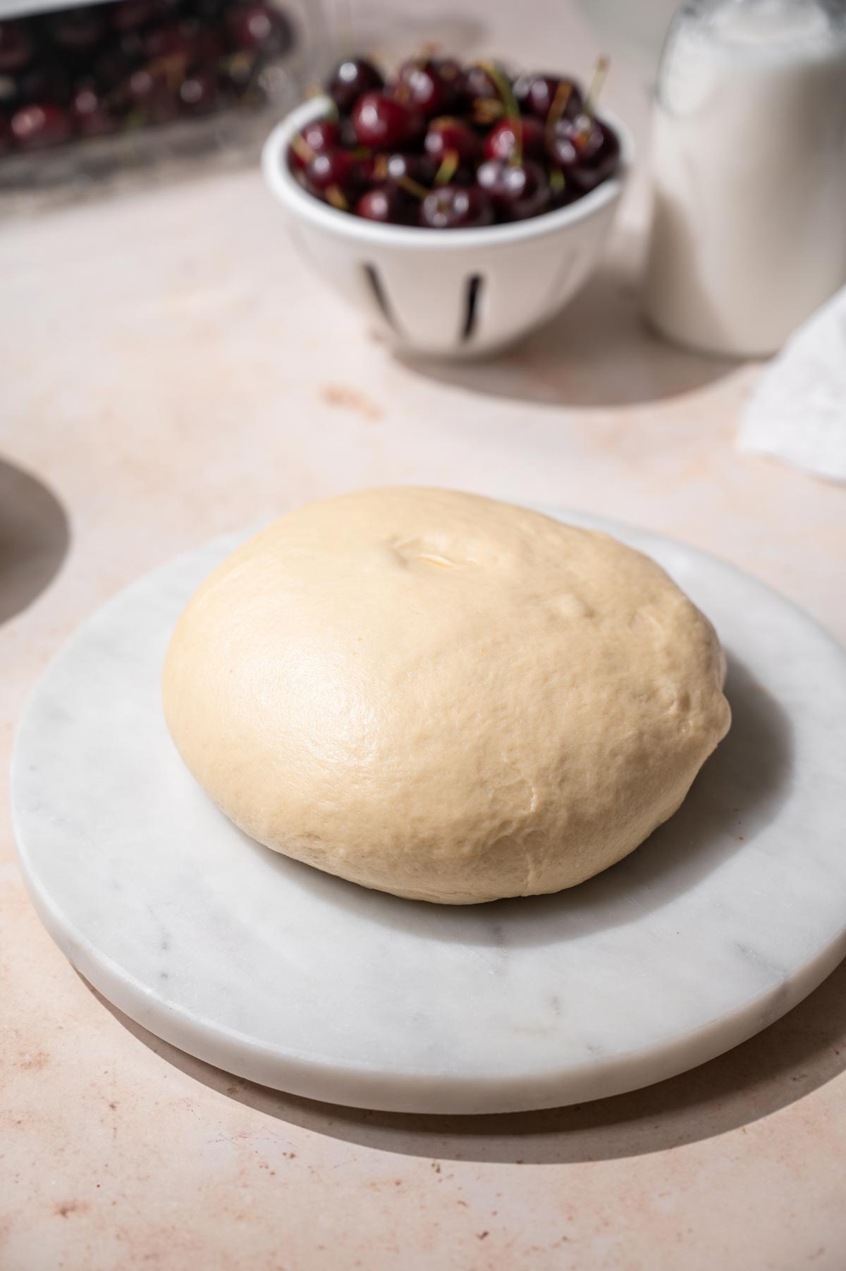 proofed vegan brioche dough on a marble cutting board.