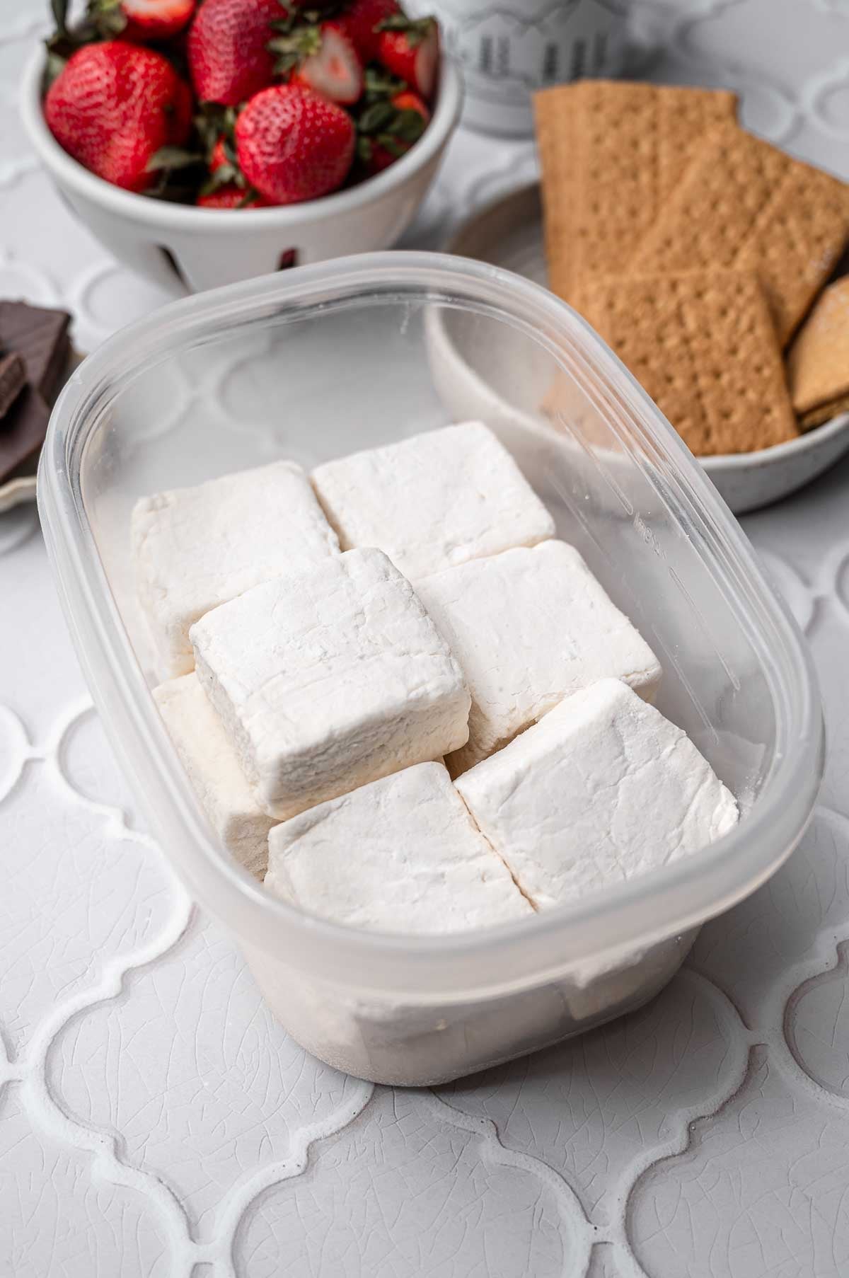 marshmallows cut in squares in a plastic storage container.