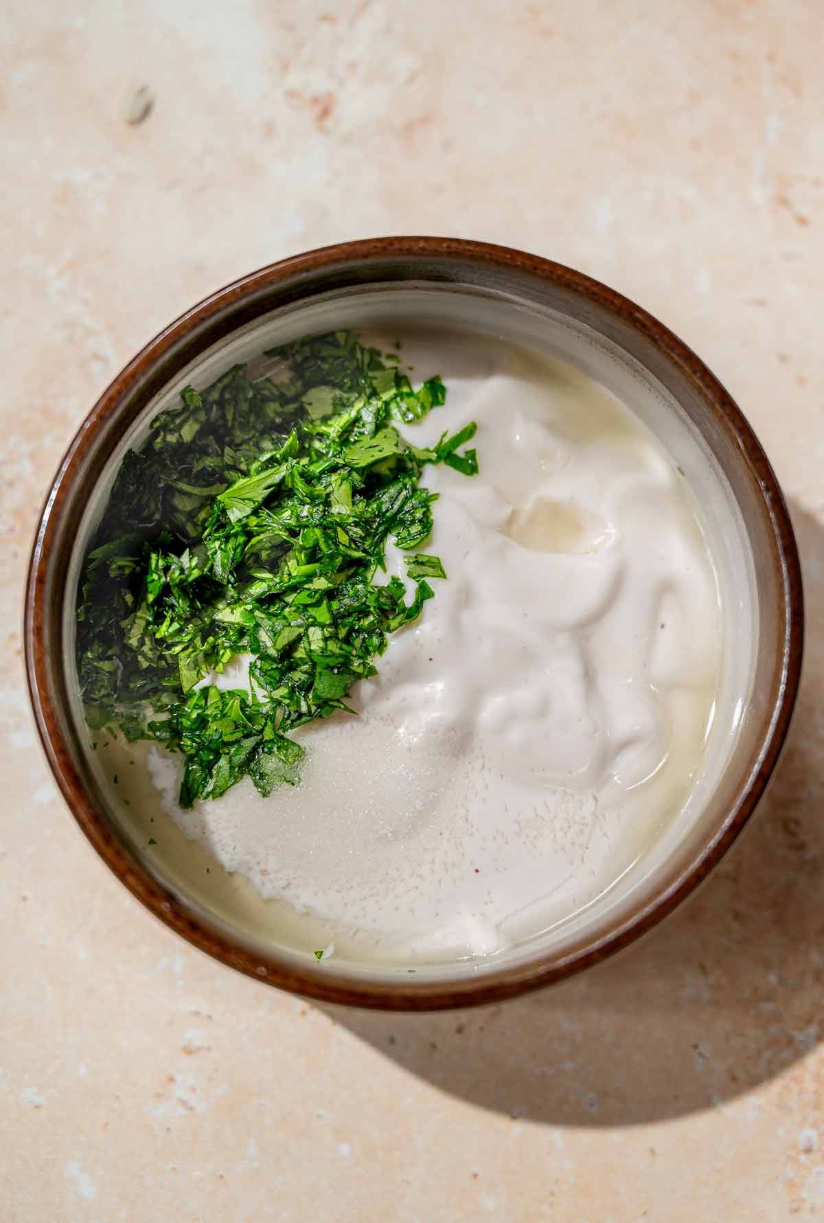 Dairy-free cilantro lime crema with chopped herbs before mixing.