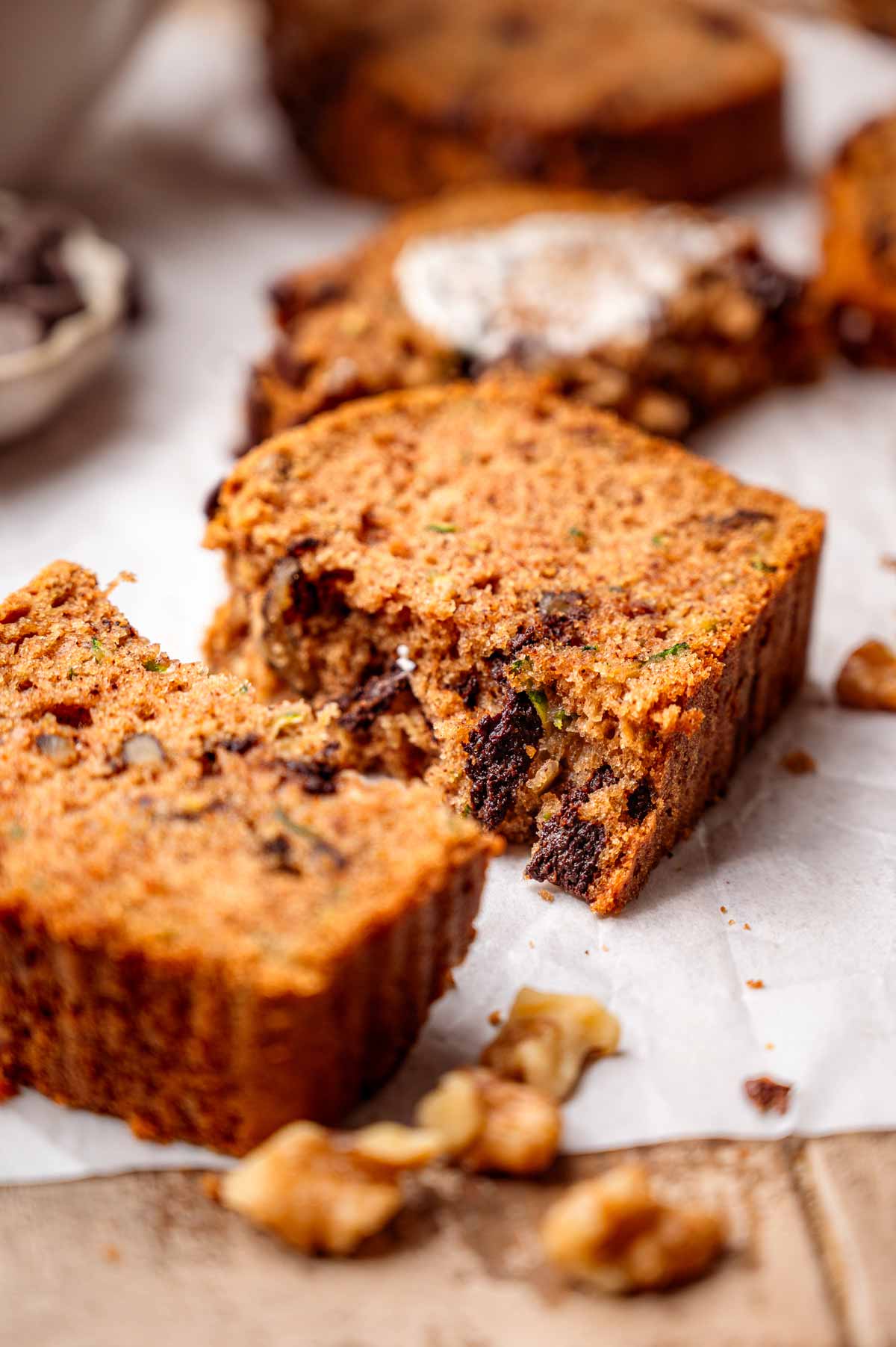 Close-up of soft vegan zucchini bread with chocolate chips, walnuts and flecks of shredded zucchini.