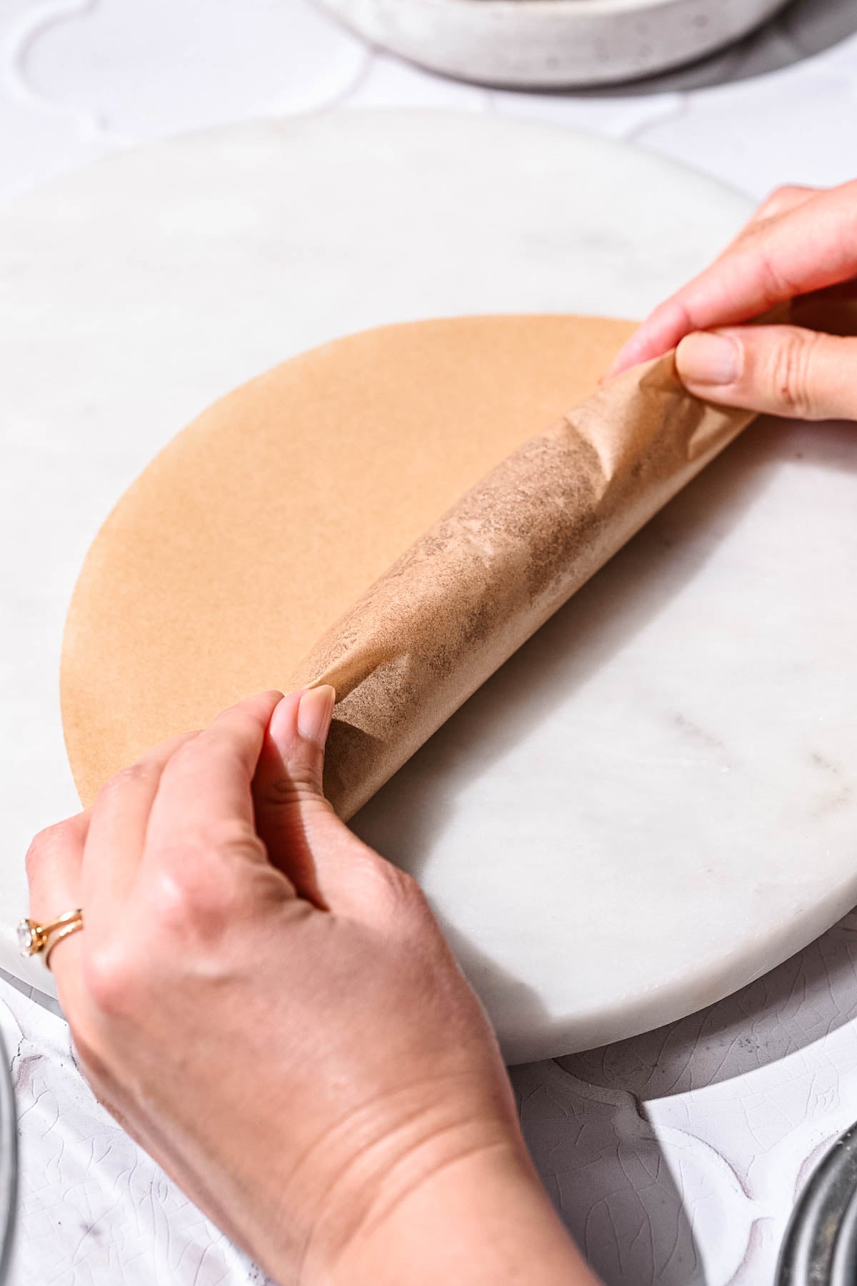 A vegan hot dog log being rolled tightly in parchment paper before wrapping.