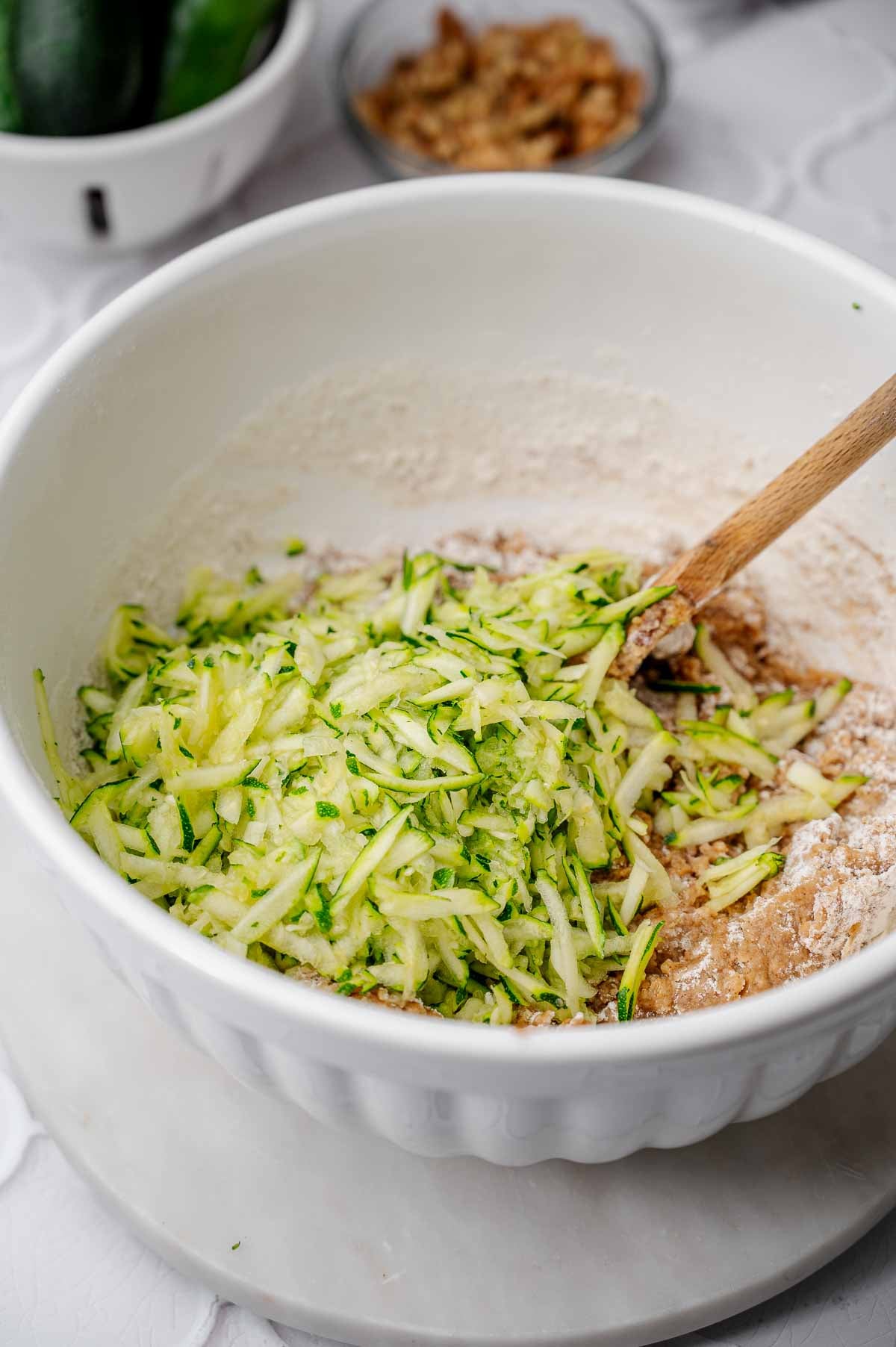 Shredded zucchini added to the zucchini bread batter before mixing.