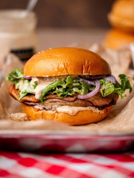 a vegan caesar sandwich with baked plant-based chicken.