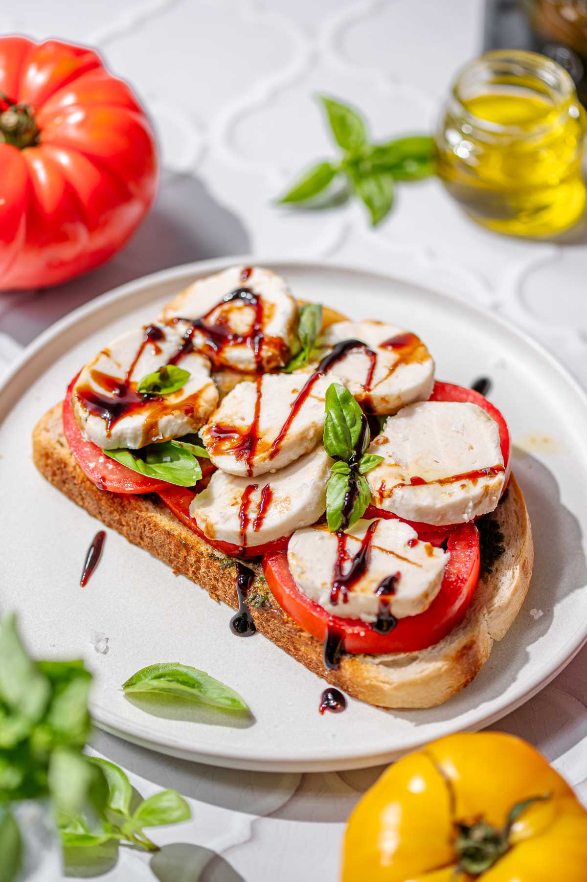 Homemade vegan mozzarella balls on a pesto caprese sandwich
