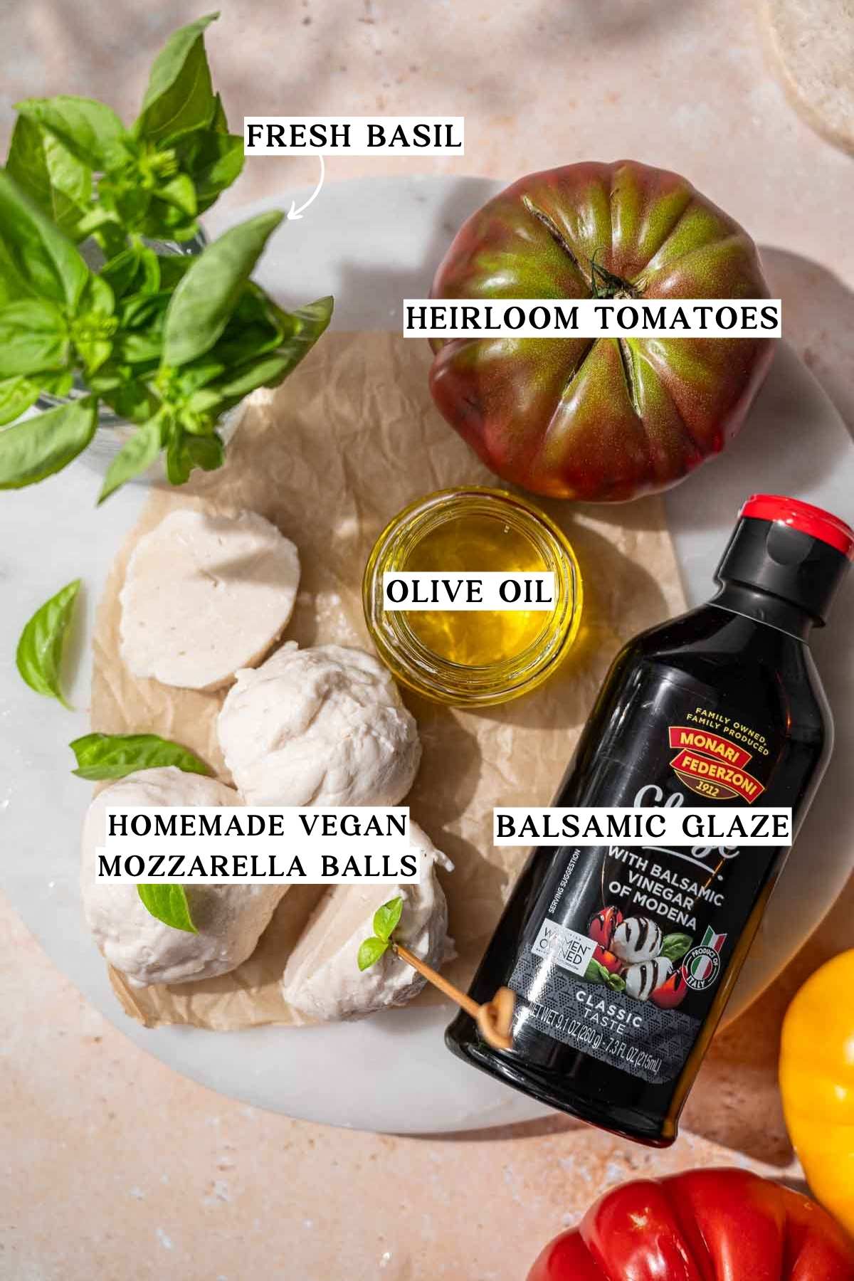 ingredients like tomatoes, basil and dairy-free mozzarella on a cutting board.