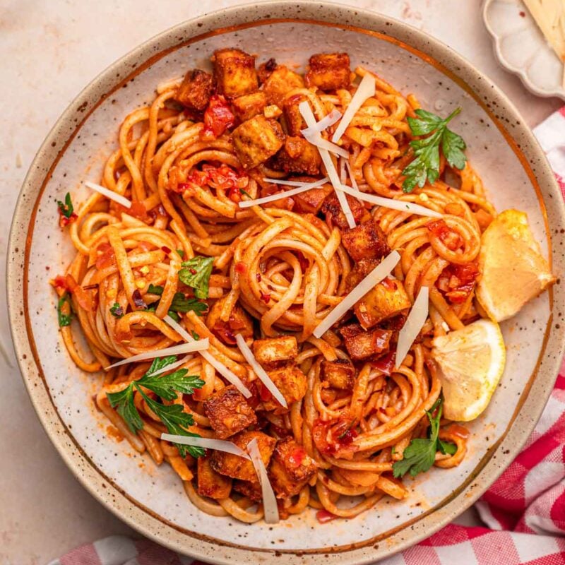 a bowl of linguine topped with a lemon tomato and chili flake sauce and crisp paprika tofu.