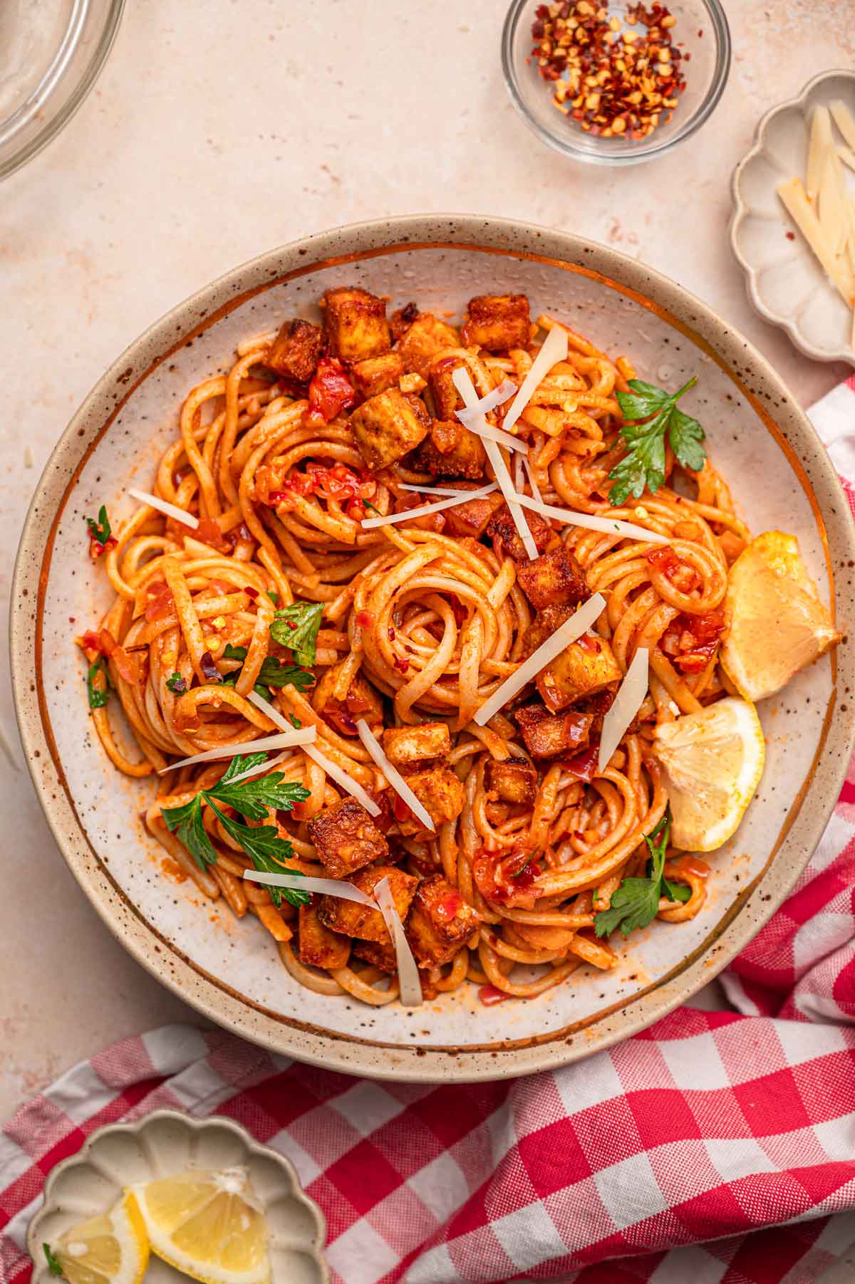 a bowl of linguine topped with a lemon tomato and chili flake sauce and crisp paprika tofu.