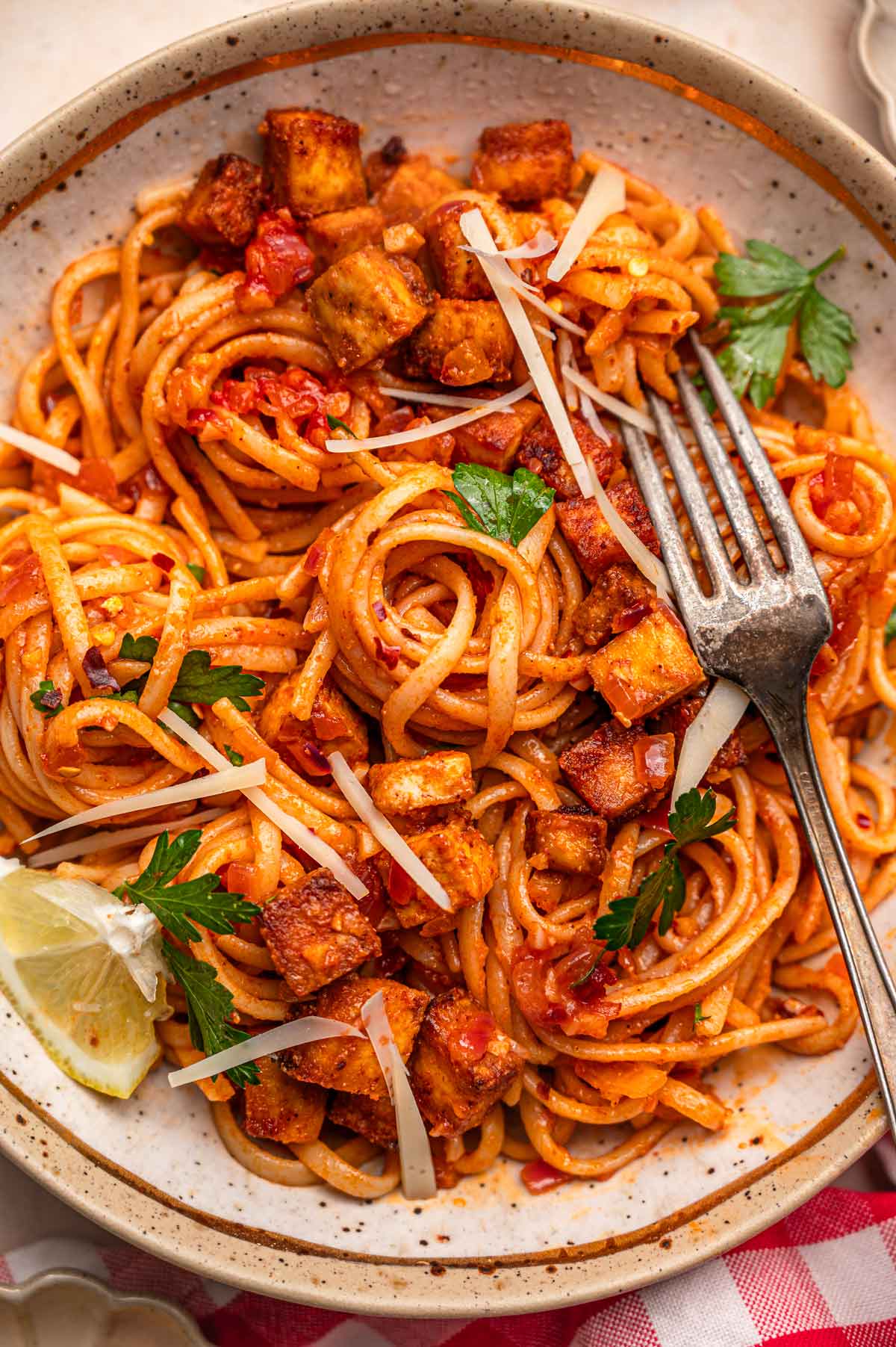 a bowl of linguine topped with a lemon tomato and chili flake sauce and crisp paprika tofu.