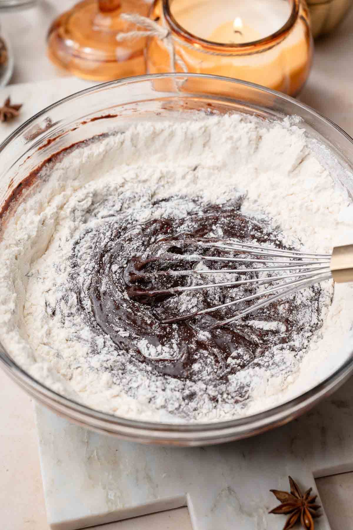 flour and leavening being whisked into the brownie batter.